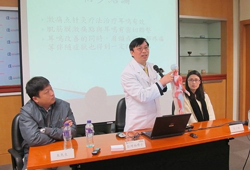 Dr. Peng Zengfu (centre) explains his clinical observations on acupuncture treatment of tinnitus with the two patients