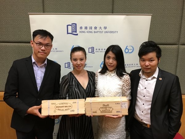 (From left) Members of the winning team John Au, Melinda Jing and Faye Chan and their coach Mr Fourson Kwok celebrate their success at the Left Bank Bordeaux Cup with two bottles of red wine, the award from winning the second runner-up prize