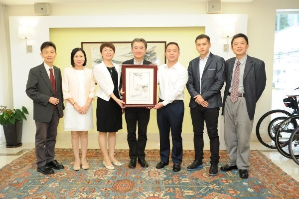 President Roland Chin (centre) receives a souvenir from Mr Eddy Zhang (third from right)