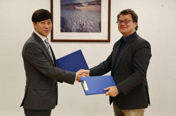 Professor Johnny Poon, Associate Dean of Faculty of Arts (left), signs MOU with Dr Philippe Peycam, Director of the International Institute of Asian Studies