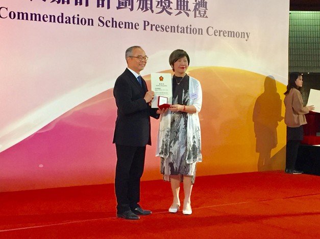 Professor Eva Man (right) receives the award from the Secretary for Home Affairs, Mr Lau Kong-wah