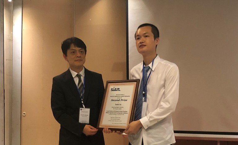 Lin Xuelei (right) receives two awards in recognition of his achievements in mathematics.