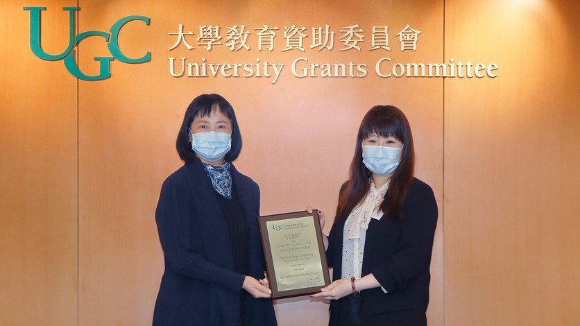 张美君教授（右）凭社交媒体网络欺凌研究项目获选为「研资局高级研究学者」。她在教资会秘书处办公室获教育局常务秘书长李美嫦女士（左）颁发奖项。