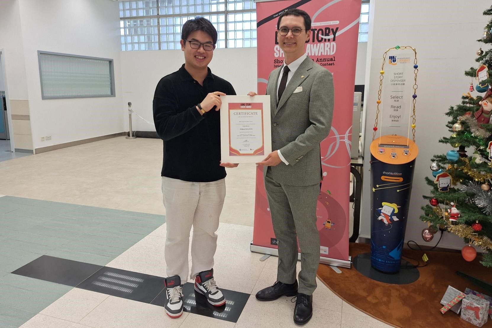 图书馆馆长陈伟程先生（右）祝贺William Susanto （左）赢得「Long Story Short Award」的「Public Winner」奖项。