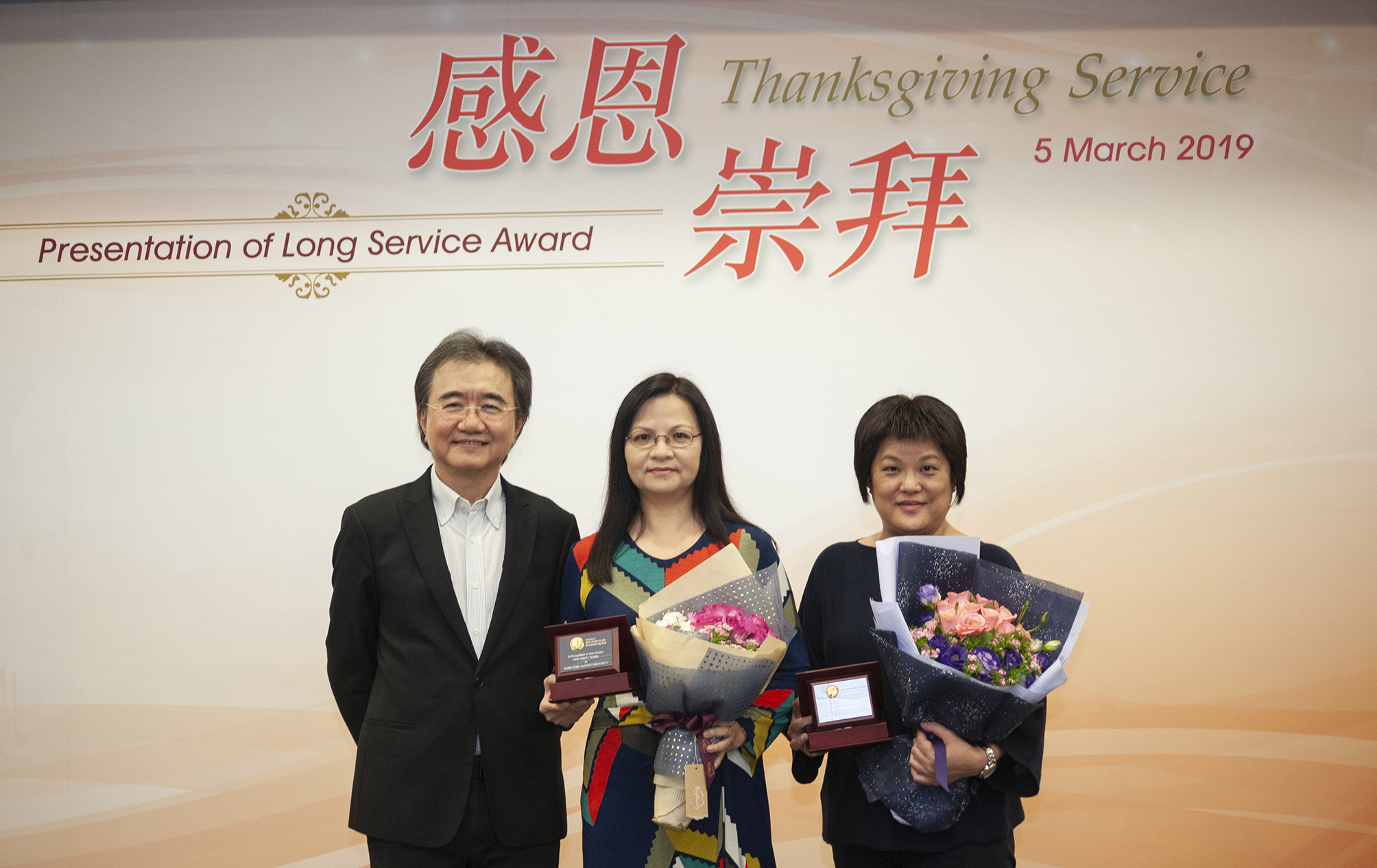 Professor Roland Chin (left) congratulates Miss Leung Kit-pik (centre) and Ms Cheung Man-yi for their 30 years of service.