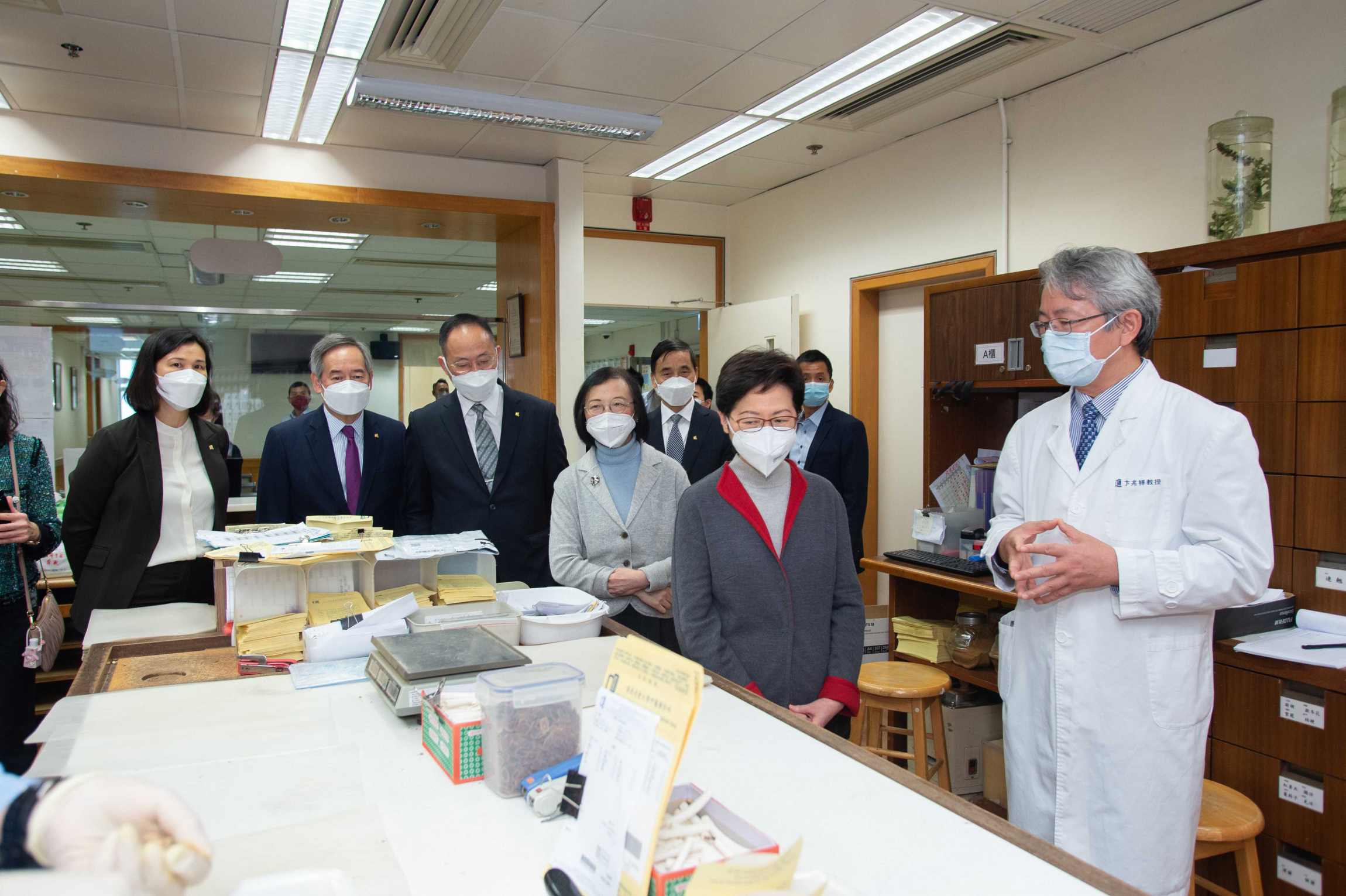 Professor Bian Zhaoxiang, Associate Vice-President (Chinese Medicine Development) of HKBU (1st right), introduces the medicine dispensing service offered by the School of Chinese Medicine for COVID-19 patients.